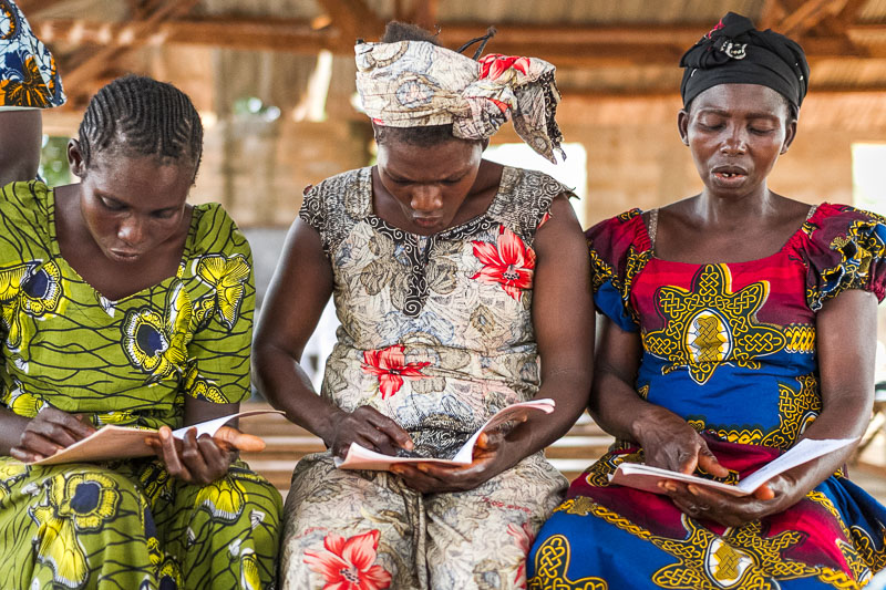 Women read from a literacy primer in an Ngbakan literacy class.